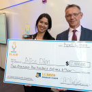 Alice Dien and Dean Jean Pierre Delplanque with an oversized winner's check.